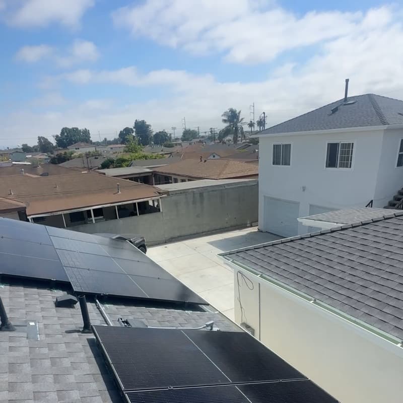 Solar panels installed on residential roof with neighborhood view